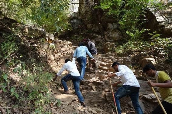 devotees climbing ugra stambha